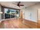Bright main bedroom featuring hardwood flooring, ceiling fan, ensuite bath, and sliding glass doors leading to a private pool at 8408 E Rancho Vista Dr, Scottsdale, AZ 85251