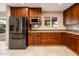 Gourmet kitchen features stainless steel appliances, custom cabinets, granite countertops, and mosaic tile backsplash at 8408 E Rancho Vista Dr, Scottsdale, AZ 85251