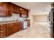 Modern kitchen boasts wooden cabinets, granite countertops, mosaic backsplash, and stainless steel appliances at 8408 E Rancho Vista Dr, Scottsdale, AZ 85251