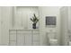 Bathroom featuring white cabinets, a toilet, and a framed drawing on the wall at 9550 W Catalina Dr, Phoenix, AZ 85037