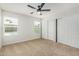 A bright bedroom boasts a ceiling fan, neutral carpet, two windows and a double door closet at 11021 N 55Th Dr, Glendale, AZ 85304