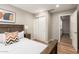 Bright bedroom featuring wood floors, a window, and a wooden bed frame with access to closet and bedroom at 1114 N Leland Ct, Gilbert, AZ 85233