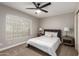 Cozy bedroom featuring a ceiling fan, neutral walls, and a comfortable bed near the window at 1114 N Leland Ct, Gilbert, AZ 85233