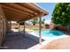Backyard featuring a covered patio, pool, mature trees, and lounge furniture at 113 N Albert Dr, Chandler, AZ 85226