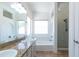 Bright bathroom featuring a double sink vanity with granite countertop, bathtub, and glass shower at 113 N Albert Dr, Chandler, AZ 85226