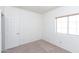 Neutral bedroom with a standard window, carpet flooring and a white door at 113 N Albert Dr, Chandler, AZ 85226