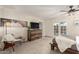 Bright bedroom with a ceiling fan, carpet floors, wooden furniture, and a glass paneled door at 12866 W Orange Dr, Litchfield Park, AZ 85340