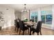 Bright dining room featuring wood floors, a modern chandelier, and a large window with plenty of natural light at 12866 W Orange Dr, Litchfield Park, AZ 85340