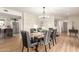 Open-concept dining room showcasing a modern chandelier, wood floors, and an archway view into the kitchen at 12866 W Orange Dr, Litchfield Park, AZ 85340