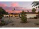 Exterior of a single story home with solar panels at sunset at 12866 W Orange Dr, Litchfield Park, AZ 85340