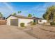 Home exterior features a garage, white brick, desert landscaping, and palm trees at 12866 W Orange Dr, Litchfield Park, AZ 85340