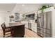 Modern kitchen with stainless steel appliances, center island with barstool seating and custom white cabinets at 12866 W Orange Dr, Litchfield Park, AZ 85340