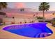 Sparkling pool with illuminated water and beautifully landscaped backyard at 12866 W Orange Dr, Litchfield Park, AZ 85340