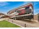 View of an RV parked in the yard. The RV is a large model with multiple slide-outs and modern design at 12866 W Orange Dr, Litchfield Park, AZ 85340