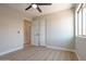 A bright bedroom features wood-look tile, closet and ceiling fan at 13170 W Clarendon Ave, Litchfield Park, AZ 85340