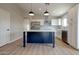 Bright kitchen with stainless steel appliances, island with stylish pendant lights, and wood-look flooring at 13170 W Clarendon Ave, Litchfield Park, AZ 85340
