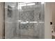 Close up of shower with decorative tile, a bench, and glass doors at 13170 W Clarendon Ave, Litchfield Park, AZ 85340