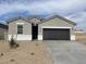Charming single-story home features a gray stucco exterior, a dark brown garage door, and low maintenance landscaping at 1359 S Vista Ave, Florence, AZ 85132