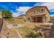 Backyard oasis featuring green grass, rock landscaping, brick fire pit, and covered patio at 15551 W Poinsettia Dr, Surprise, AZ 85379