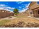 Spacious backyard featuring a fire pit, block wall for privacy, desert landscaping and a small lemon tree at 15551 W Poinsettia Dr, Surprise, AZ 85379