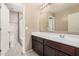 Neutral bathroom features a tile floor, white sink, and a mirror at 15551 W Poinsettia Dr, Surprise, AZ 85379