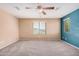 Comfortable bedroom with plush carpet, ceiling fan, and windows offering neighborhood views at 15551 W Poinsettia Dr, Surprise, AZ 85379