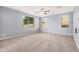 Spacious bedroom featuring neutral carpet, three large windows that provide natural light, and light blue paint at 15551 W Poinsettia Dr, Surprise, AZ 85379