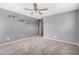 Gray bedroom features a ceiling fan and carpeted floors at 15551 W Poinsettia Dr, Surprise, AZ 85379