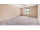 Neutral bedroom featuring a ceiling fan and a large window overlooking the outside at 15551 W Poinsettia Dr, Surprise, AZ 85379