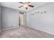 Comfortable bedroom with modern ceiling fan, plush carpet and an adjacent closet at 15551 W Poinsettia Dr, Surprise, AZ 85379