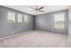 Gray bedroom featuring carpeted floors, ceiling fan, and good natural light at 15551 W Poinsettia Dr, Surprise, AZ 85379