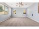 Spacious bedroom featuring neutral carpet, three large windows that provide natural light, and light blue paint at 15551 W Poinsettia Dr, Surprise, AZ 85379