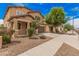 Charming two-story home featuring a well-manicured front yard, covered porch, and attached two-car garage at 15551 W Poinsettia Dr, Surprise, AZ 85379