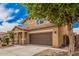 Charming two-story home featuring a well-manicured front yard, covered porch, and attached two-car garage at 15551 W Poinsettia Dr, Surprise, AZ 85379