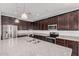 Modern kitchen featuring dark cabinets, stainless steel appliances, granite countertops, and a large island with a sink at 15551 W Poinsettia Dr, Surprise, AZ 85379