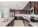 Well-equipped kitchen featuring stainless steel appliances, granite counters, tile backsplash, and modern cabinetry at 15551 W Poinsettia Dr, Surprise, AZ 85379