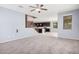 Open-concept living room featuring plush gray carpet, ceiling fan, and a view into the modern kitchen at 15551 W Poinsettia Dr, Surprise, AZ 85379