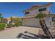 Inviting two-story home featuring a tile roof, two-car garage, and desert landscaping under a bright blue sky at 1610 W Maplewood St, Chandler, AZ 85286