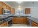 Well-lit kitchen boasting stainless steel appliances, wood cabinets, tile backsplash, and granite countertops at 1610 W Maplewood St, Chandler, AZ 85286