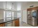 Bright, updated kitchen with a stainless refrigerator, granite countertops, and an island overlooking a sunny living area at 1610 W Maplewood St, Chandler, AZ 85286