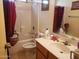 Cozy bathroom featuring a shower-tub combo, vanity with sink, toilet, and tile floors at 1623 E Fremont Rd, Phoenix, AZ 85042