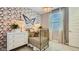 Bright Bedroom featuring butterfly wallpaper, a stylish crib, and a comfortable dresser at 16714 W Audrey Ln, Surprise, AZ 85387