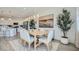 Bright dining area featuring modern lighting, stylish furniture, and an elegant painting, adjacent to the kitchen at 16714 W Audrey Ln, Surprise, AZ 85387