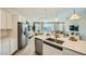 Modern kitchen featuring white countertops, stainless steel appliances, and an open layout with views to the living area at 16714 W Audrey Ln, Surprise, AZ 85387