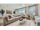 Comfortable living room featuring a large sectional sofa, elegant decor, and natural light from the large windows at 16714 W Audrey Ln, Surprise, AZ 85387