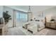 This main bedroom features a decorative light fixture, a plush bed, and well-lit windows at 16714 W Audrey Ln, Surprise, AZ 85387