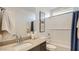 Well-lit bathroom with a single sink vanity, framed mirrors, and shower and bath combo at 16739 W Charlotte Dr, Surprise, AZ 85387