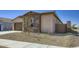 Angle view of a single-story home showing desert landscaping, neutral color palette and a quaint design at 16933 W Bronco Trl, Surprise, AZ 85387