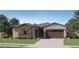 Charming single-story home featuring a stone facade, two-car garage, and well-manicured lawn at 16933 W Bronco Trl, Surprise, AZ 85387