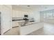 Open-concept kitchen features white cabinetry, granite countertops, a large island, and stainless steel appliances at 16933 W Bronco Trl, Surprise, AZ 85387